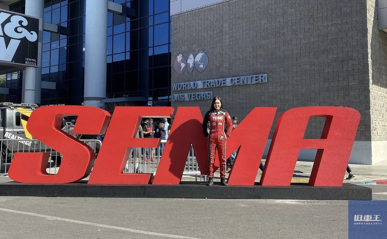 SEMAショーの看板前でポーズをとる塚本ナナミ