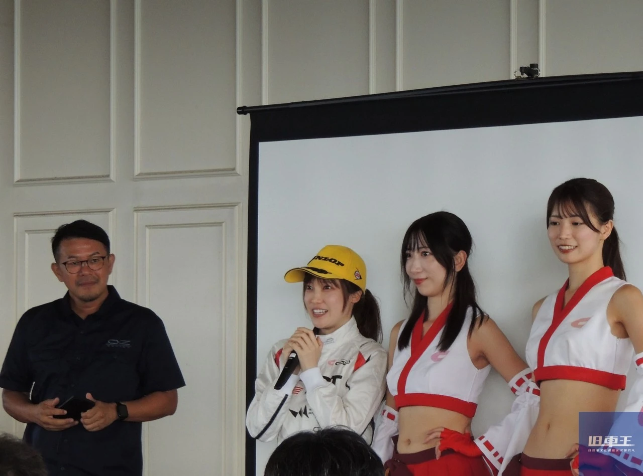 マイクを持って話をしている女性ドライバー