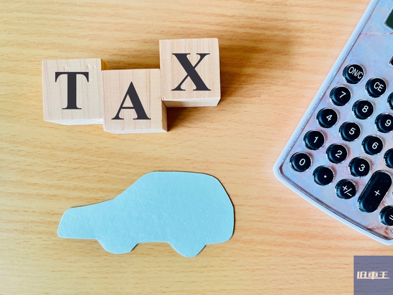 TAXという文字の積み木と車の形の紙と電卓
