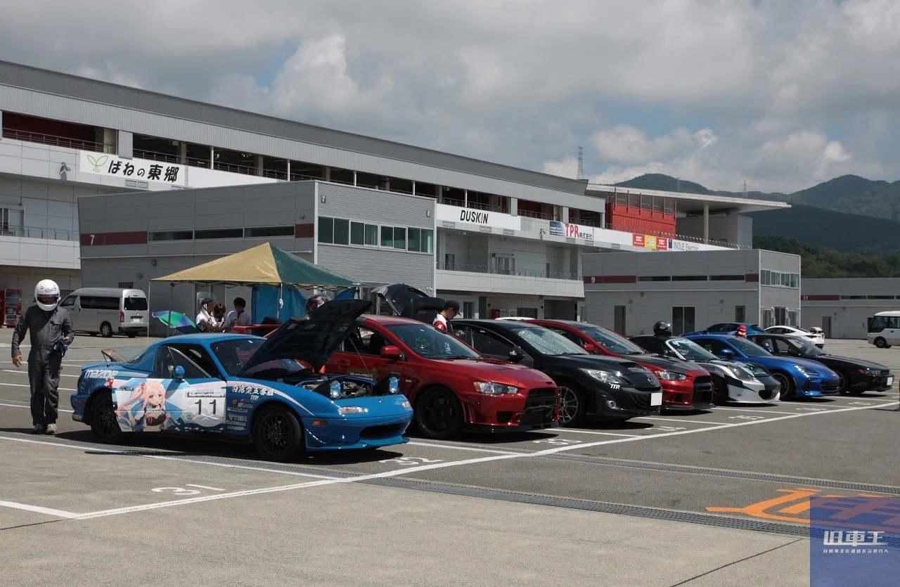 ヘルメットを被った参加者と駐車場に整列する車