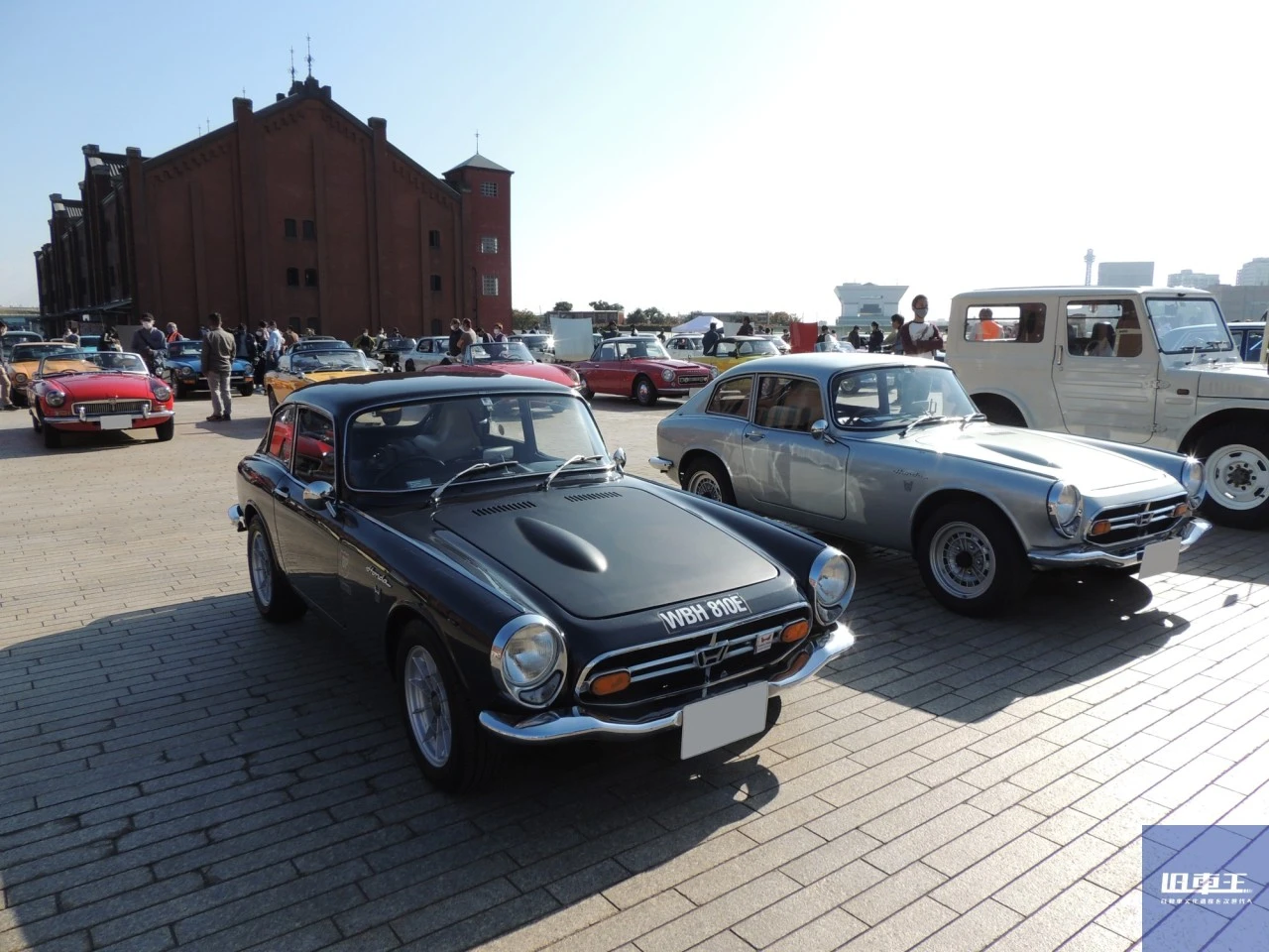 赤レンガ倉庫を背に停車するたくさんのクラシックカー